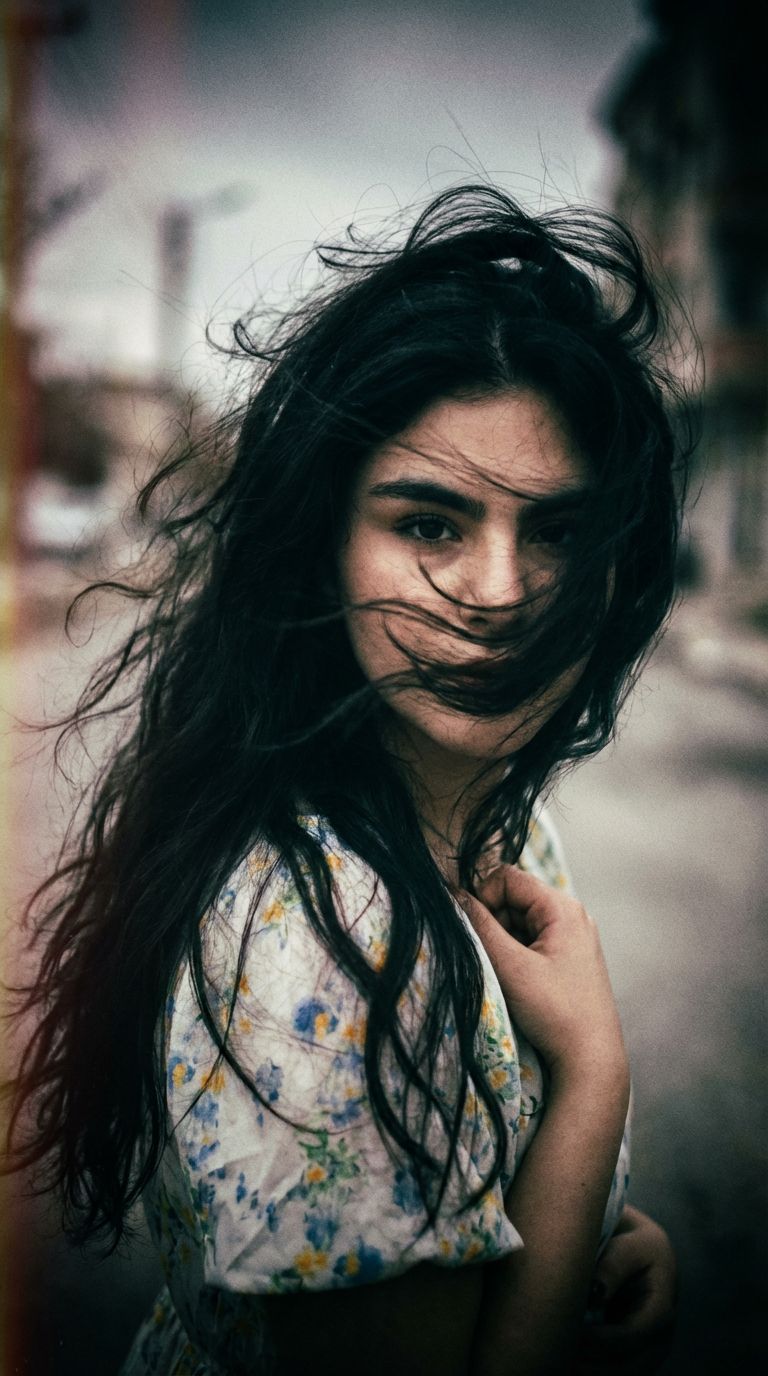 Nano Banana prompt: a woman with long wild hair on a wind...